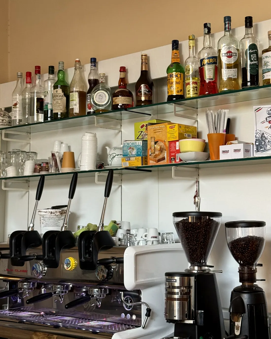 Il banco del bar con la macchina del caffè, i macinini e le bottiglie